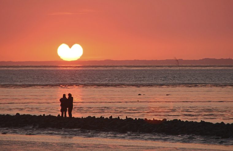 ハート型の夕日とカップル