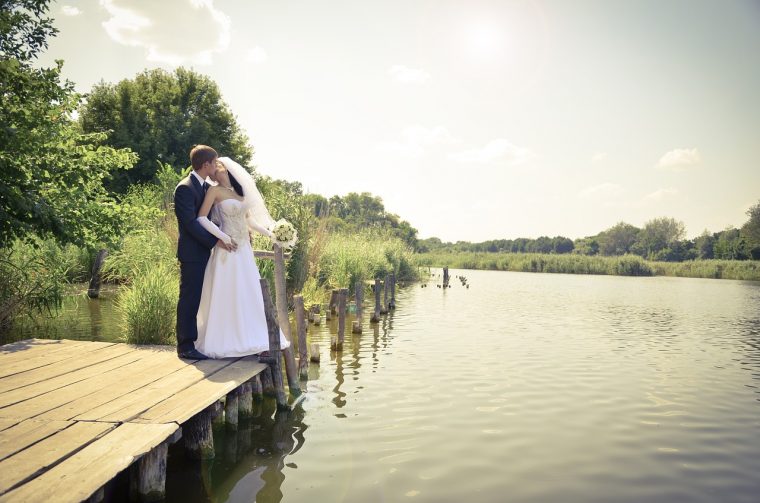 湖のほとりで誓いのキスをする夫婦